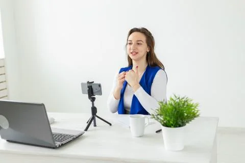 Blogging, work and vlog concept - young woman blogger is speaking to the camera Stock Photos