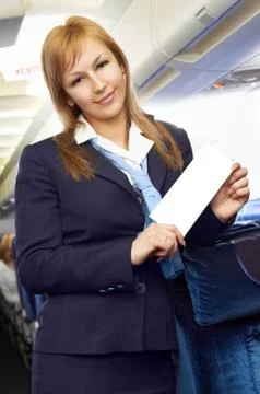 Blond air hostess (stewardess) in the empty airliner cabin Foto stock