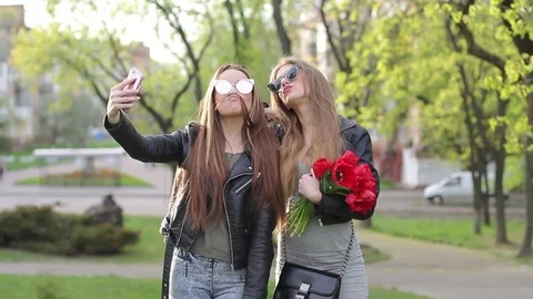 Blond and brunette make a joint selfie in nature Stock Footage 75003105