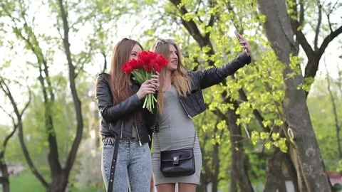 Blond and brunette make a joint selfie in nature Stock Footage 75003305