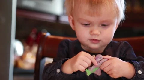 Blond baby girl playing with modelling clay Stock Footage 58074553