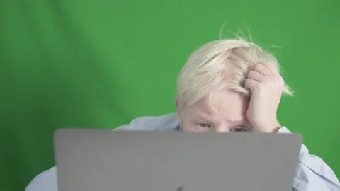 A blond boy is engaged online at the computer against the background of a Stock Footage 185508963