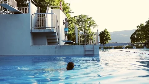 Blond boy jumping into the water. Stock Footage 103481793