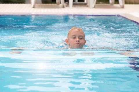 A blond boy learning to swim Stock Photos