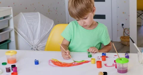 A blond boy paints a colored rainbow 動画素材 220875902