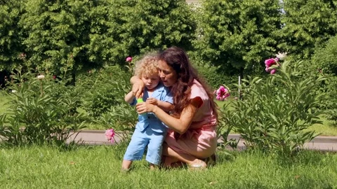 A blond boy plays inflatable ball with his mother in the Park summer day, 4K Stock Footage 133904325