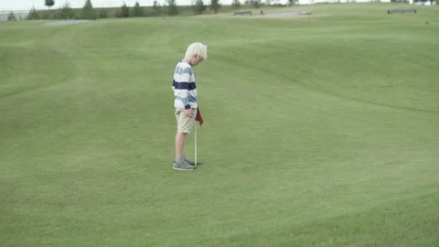 A blond boy is running around the golf course Stock Footage 111032308