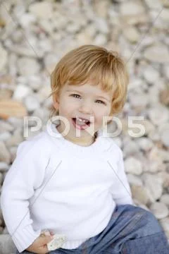 Blond boy smiling on a rolling stones background Stock Photos