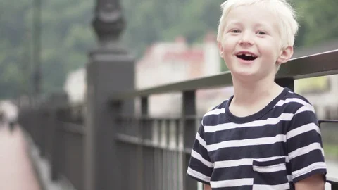 The blond boy is standing by the bridge and talking Stock Footage 91976543