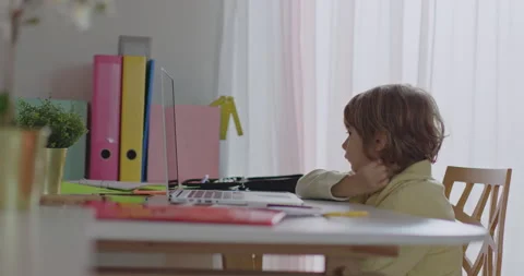 Blond boy studying at home using laptop during daytime Stock Footage 276176859