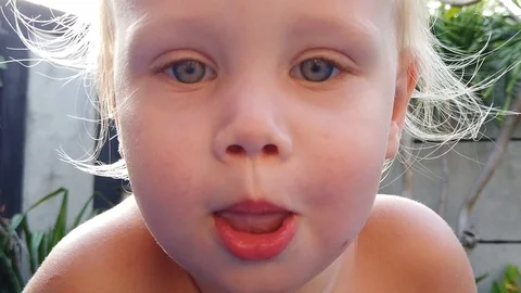 Blond boy of two years grimaces and shows his tongue. Stock Footage 107859972