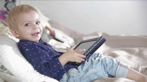 Blond boy is using a tablet. FULL HD Stock Footage 73961840