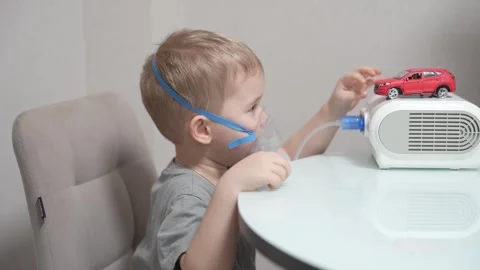 Blond child inhales vapors containing medications from inhaler. Stock Footage 331663106