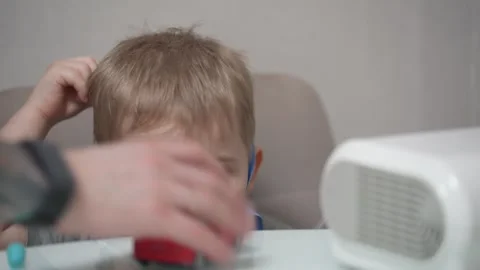 Blond child inhales vapors containing medications from inhaler. Stock Footage 331663209