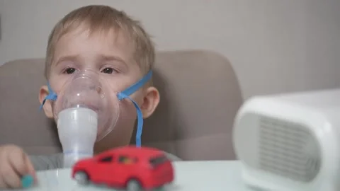 Blond child inhales vapors containing medications from inhaler. Stock Footage 331663236
