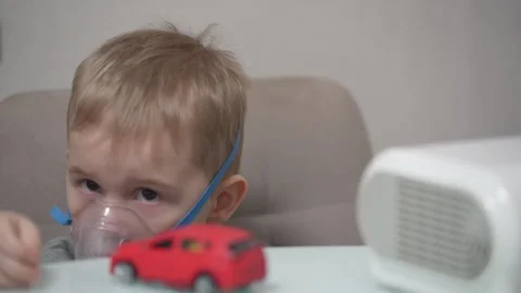Blond child inhales vapors containing medications from inhaler. Stock Footage 331663246
