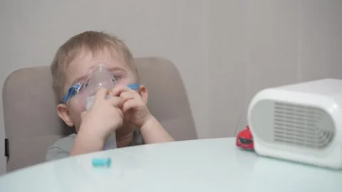 Blond child inhales vapors containing medications from inhaler. Stock Footage 331663284