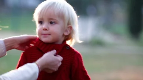 Blond child red dressed with mum outdoor in winter time Stock Footage
