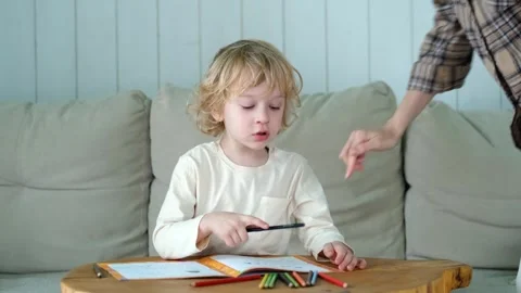 Blond curly boy doing homework in a notebook Video stock 296447387