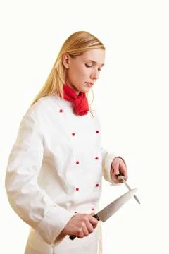 Blond female chef sharpening kitchen knife 스톡 사진