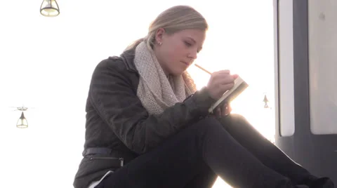 Blond girl making notes outdoors Stock Footage 33736396