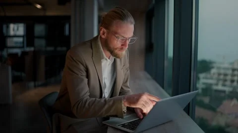 A blond guy in glasses and a light brown suit notices an error on the laptop 스톡 동영상 251115780