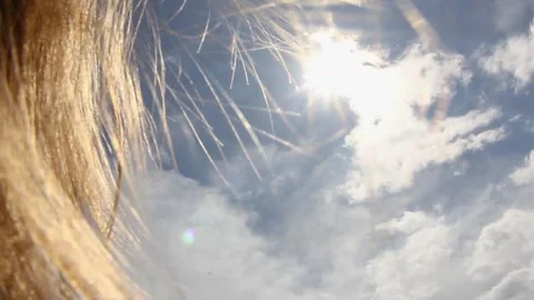 Blond hair developing in the sun against the sky Stock Footage 240122309