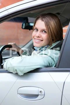 Blond hair woman driver looking back from car window Stock Photos