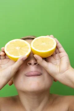 Blond-haired 7-year-old boy with two lemons over his eyes Foto stock