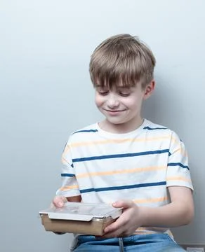 Blond-haired boy with a container of ready-made food. Food delivery, ready meals Stock Photos