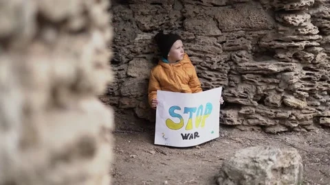 The blond-haired boy is hiding under a rock Stock Footage 175996901