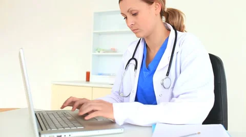 Blond-haired doctor working on her laptop Stock-Footage 4975833
