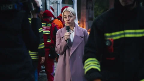 Blond journalist reporting from disaster site Stock Footage 166146275