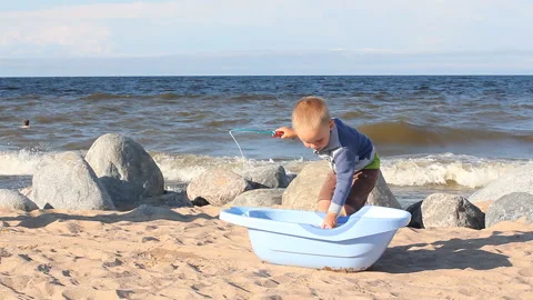 The blond kid is playing in the summer on the beach. Stock Footage 89226919