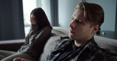 A blond man switches the TV using the remote control and does not pay attention Stock Footage 305772807