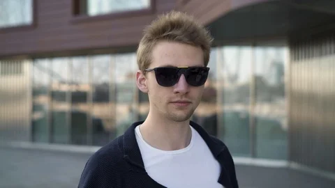 Blond man taking off sunglasses looking surprised Video stock 98248329
