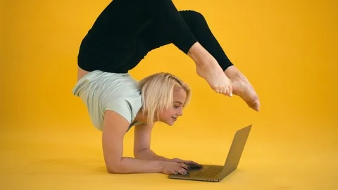 Blond model size plus practice yoga handstand pose and use laptop at yellow Video stock 97266237