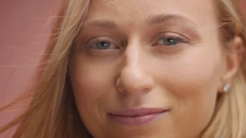 Blond model in studio on pink background with hair blowing in air Stock Footage 107516659