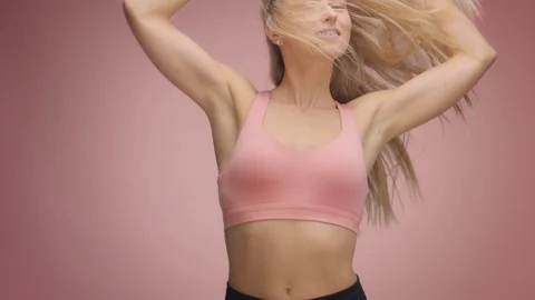 Blond model in studio on pink background with hair blowing in air Stock Footage 107516741