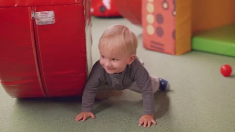 Blond toddler gets up ater falling down and runs to mom and continues playing Stock Footage 84332798