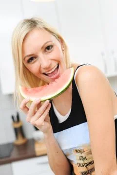 Blond woman eats melon Stock Photos