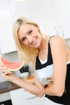 Blond woman eats melon Stock Photos