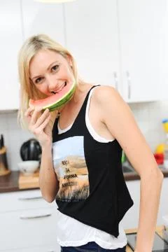 Blond woman eats melon Stock Photos