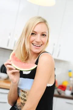 Blond woman eats melon Stock Photos