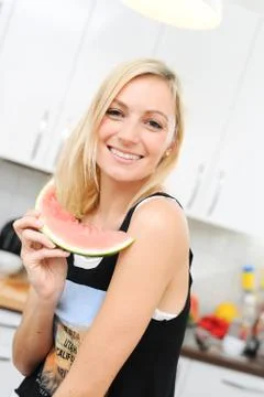 Blond woman eats melon Stock Photos