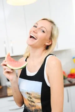Blond woman eats melon Stock Photos