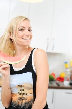 Blond woman eats melon Stock Photos