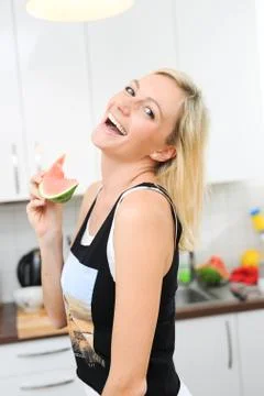 Blond woman eats melon Stock Photos