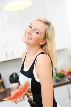 Blond woman eats melon Stock Photos