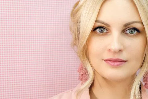 Blond woman in pink colors. Girl looks into the camera close-up. Stock Photos